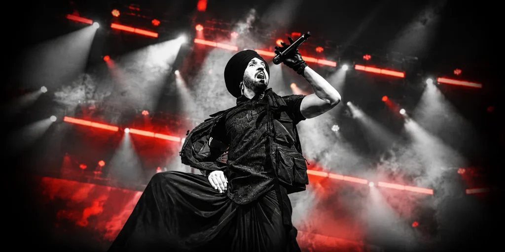 Diljit Dosanjh performing at once of his concert in a stadium